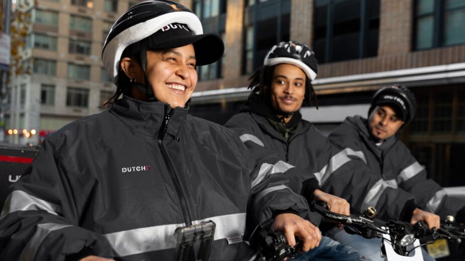 delivery men on e-bikes smiling