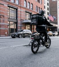 delivery man on e-bike carrying case